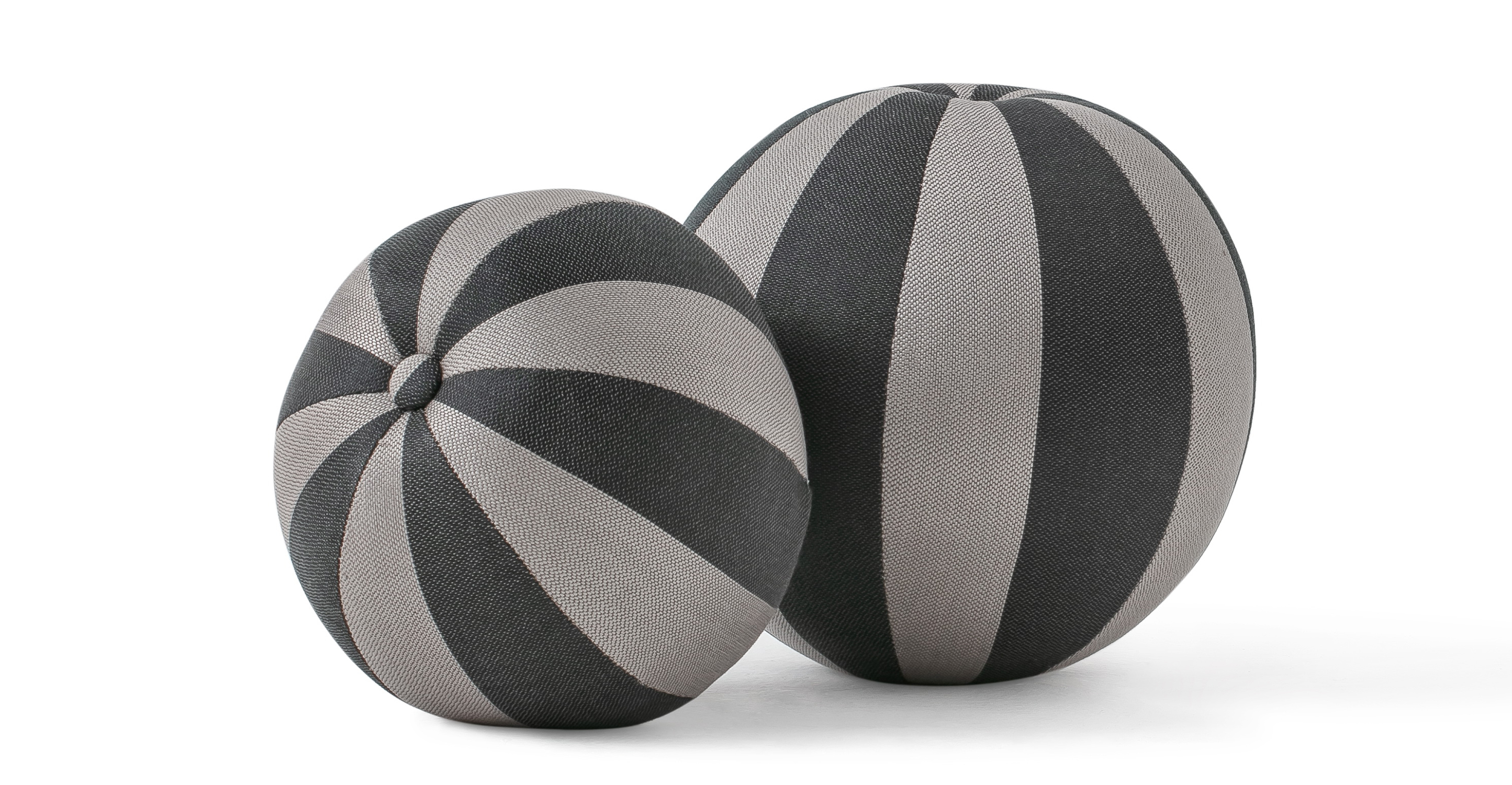 Set of two round ball pillows, one larger and one smaller. The ball has a button at center and uses several areas of stitching to create the tight ball shape.