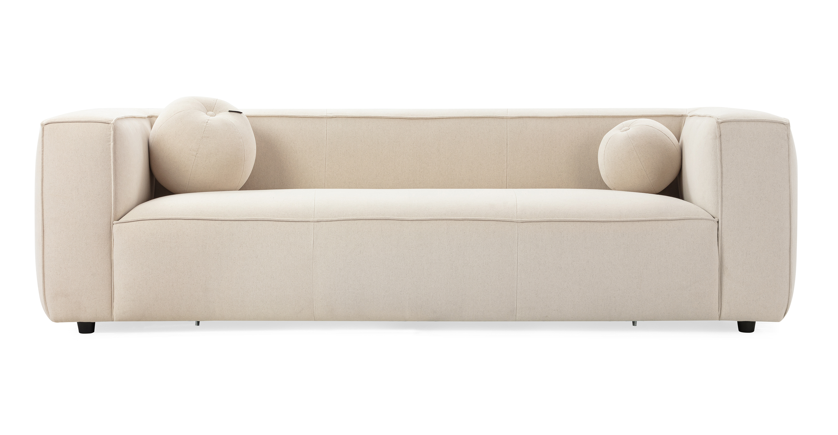 Soho Canvas 3.5 sofa has a modern and sleek low profile. The sofa is supported by small black legs that allow the sofa to be close to the floor without touching. The sofa seat cushion is one thick solid piece, the arms and back are rectangle in shape. All the cushion edges are finished in piping and have interest seams to visually divide up the one seat cushion. Two matching round orb pillows are included.