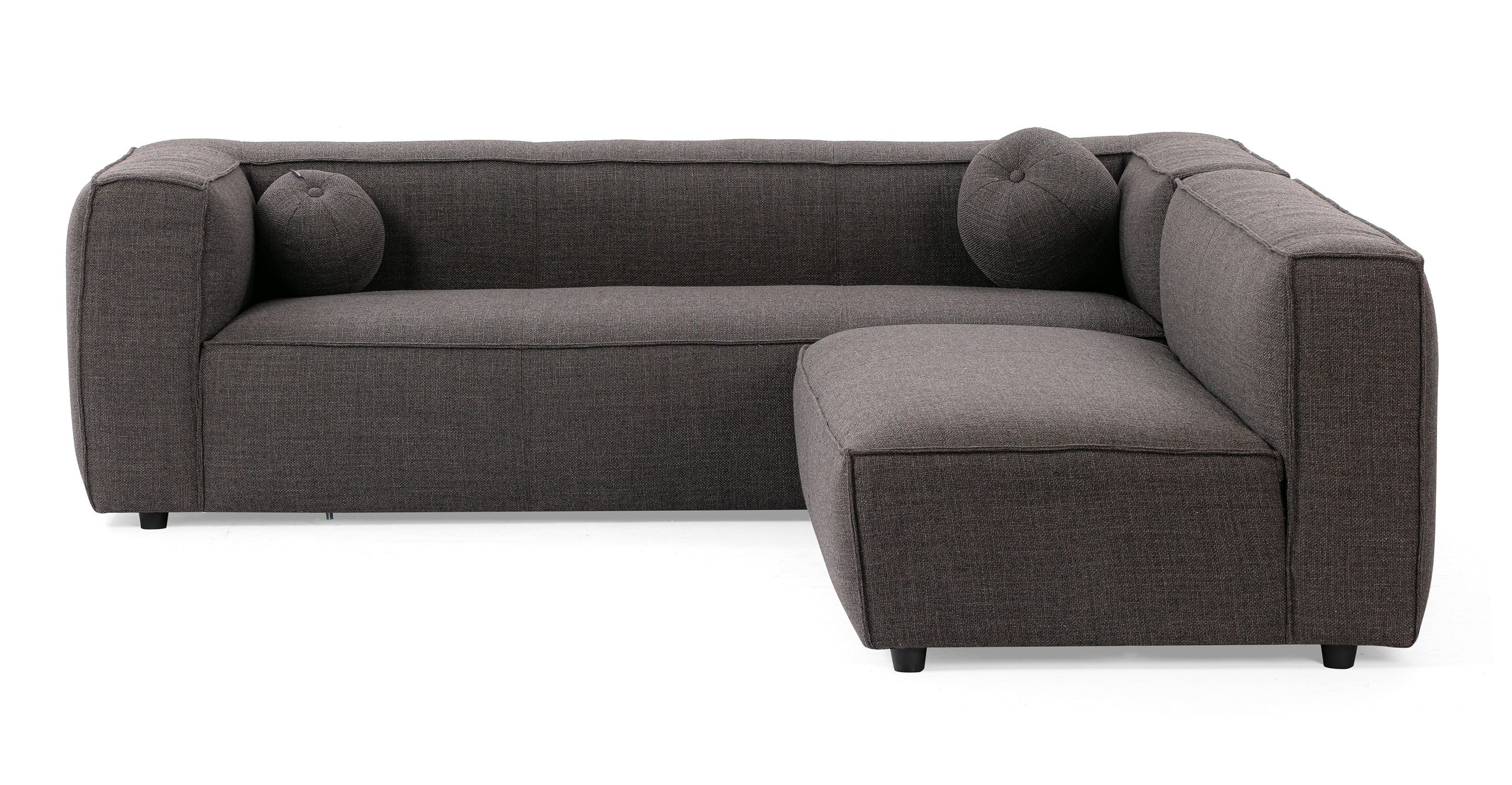 Soho Dior 96 reversible sofa has a modern and sleek low profile. The modular set connects a 3.5 sofa with arms, to an armless sofa, creating a unique L shape. This series is supported by small black legs that allow the sofa to be close to the floor without touching. The sofa seat cushion is one thick solid piece, the arms and back are rectangle in shape. All the cushion edges are finished in piping and have interest seams to visually divide up the one seat cushion. Two matching round orb cushions are included.