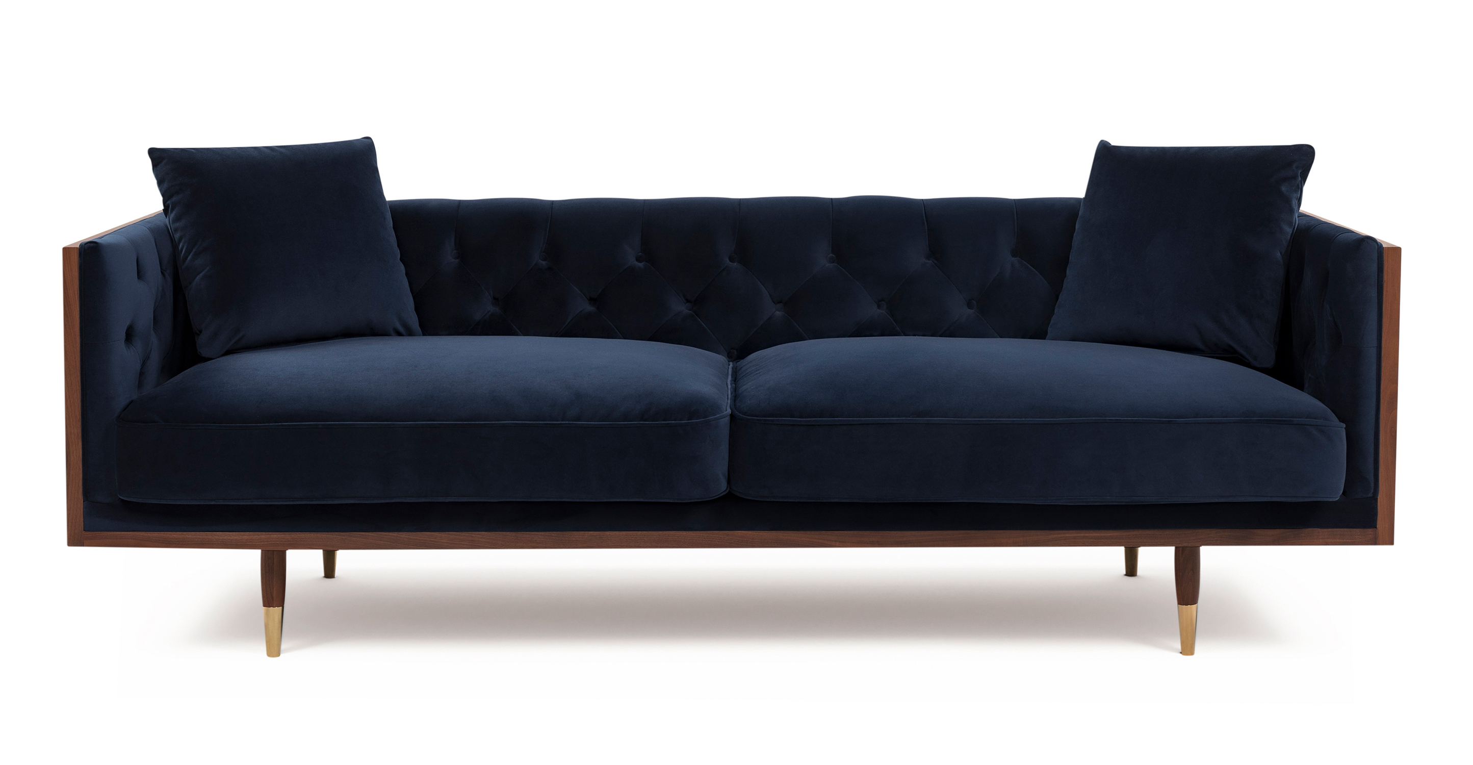 Woodneo Marine deep blue velvet is a walnut wood wrapped sofa.  The top and  of the arms and back are all walnut wood rectangles, creating a box shape. The interior of the sofa back and seat are affixed and tufted cushions. The two seat cushions are smooth and removable. There are four included throw pillows. The legs are matching walnut wood, tapered, and brass tipped. 