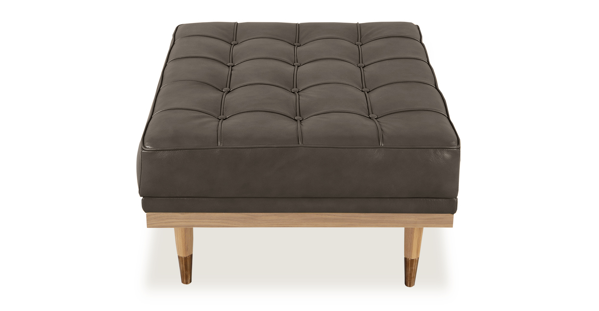 Woodrow ottoman in grey Leather. There is button tufting on the ottoman cushions. The frame and legs are natural wood toned. The legs have silver colored ferrules on the ends. The leather color is grey.